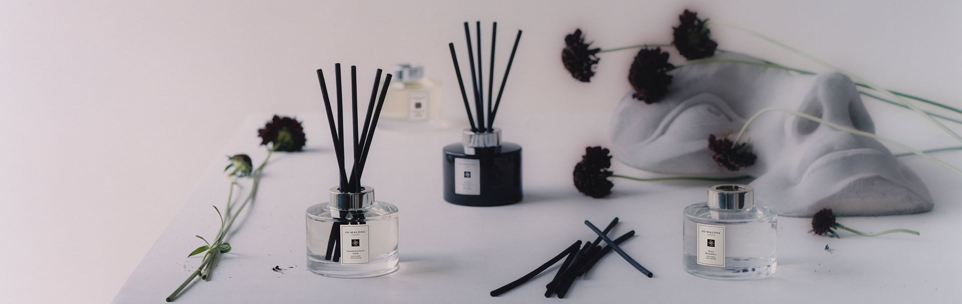 image of mantlepiece with Jo Malone travel candle, diffuser, candle & room spray in a range of scents alongside a bust