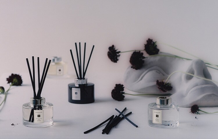 image of mantlepiece with Jo Malone travel candle, diffuser, candle & room spray in a range of scents alongside a bust